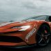 Dynamic shot of an electric sports car adorned with decals on a rainy day in Budva, Montenegro.